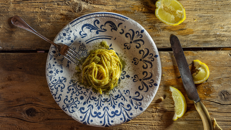 A plate of coiled cacio e pepe on a wooden table
