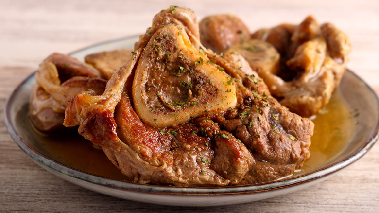 Hunks of veal and bone are gathered on a ceramic plate