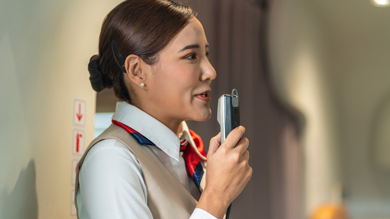 A flight attendant making an announcement.
