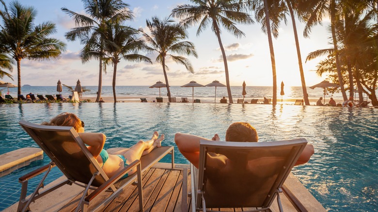 Adult couple relaxing by pool