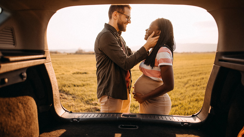 smiling couple with pregnant woman