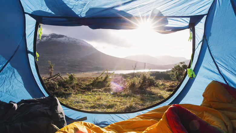 View of the Scottish Highlands as seen from inside a tent with its doors rolled open.