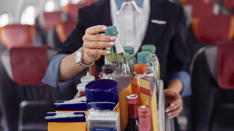 Flight attendant grabbing bottle