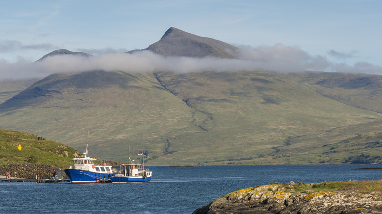 Ben More on the Isle of Mull viewed from the shoreline with two fishing vessels in the foreground