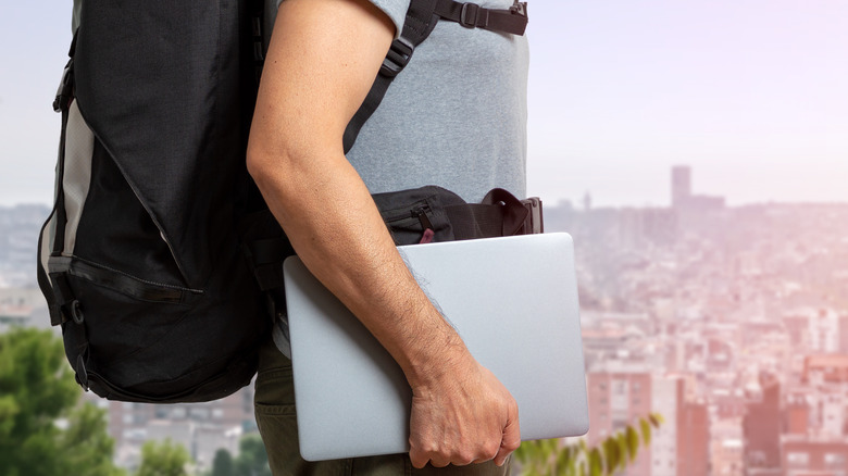 backpacker holding laptop in the city