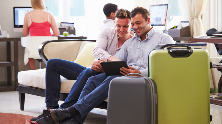 couple in hotel lobby with suitcases