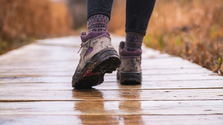 boots walking on wet boardwalk