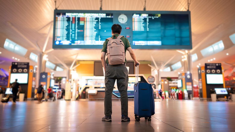 Man looking at flight schedule