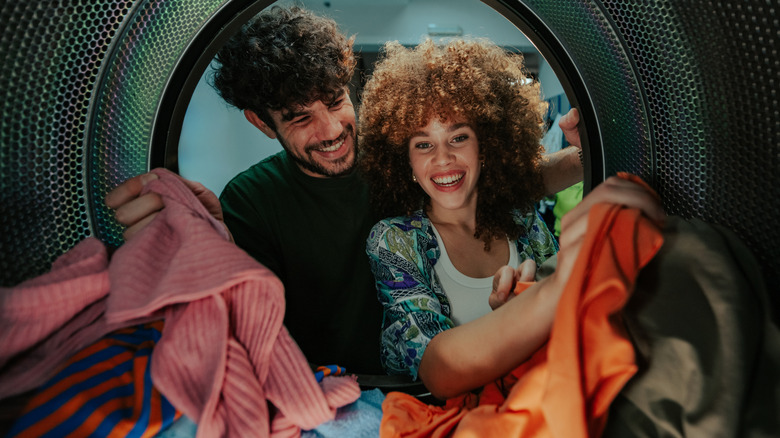two people with smiles looking into the washing machine