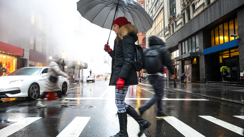 Person crossing New York crosswalk in the rain