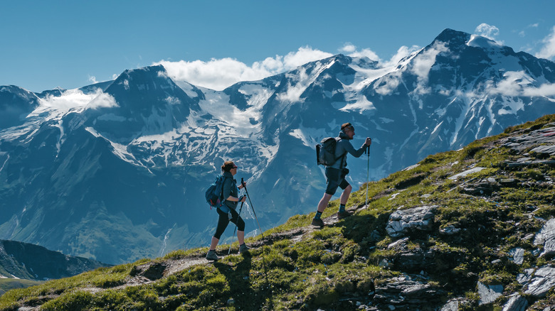 Two young hikers (a couple) walking up a mountain in Austria 