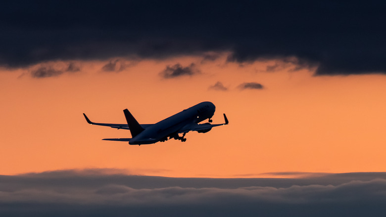 Plane flying at sunset