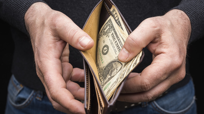 man holding wallet with money