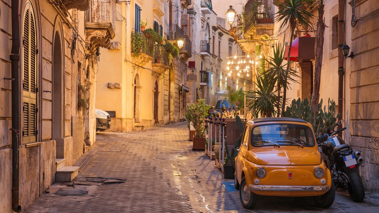 Yellow car parked on Italian street in evening