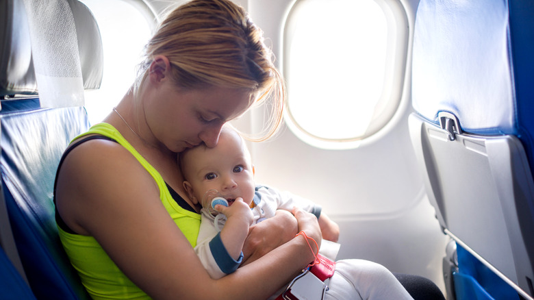 Woman holding baby on a plane