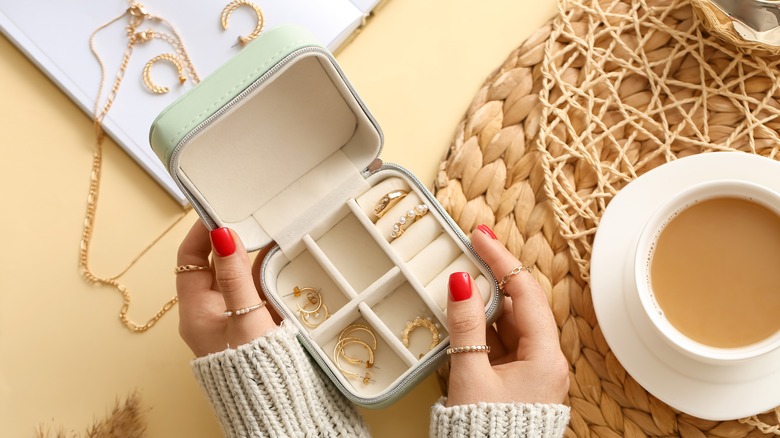 Hands holding open jewelry box