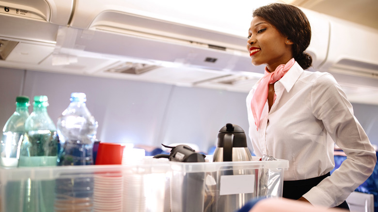 member of cabin crew serving drinks on plane