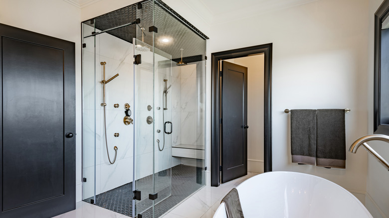 A glass-enclosed shower in a hotel bathroom