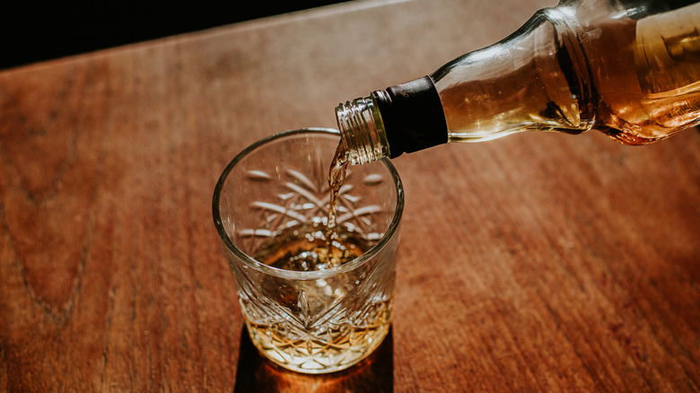 Bottle of whisky pouring into glass
