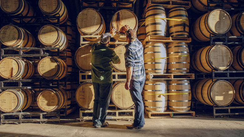 Two people admiring a whiskey barrel