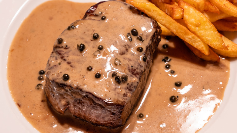 Steak au poivre on a plate with fries on the side