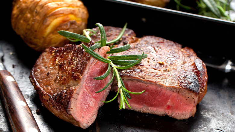A primium steak, cooked medium rare, cut in two