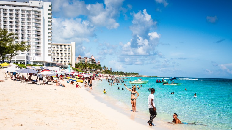 People play in the water near high rises at Cabbage Beach, Bahamas