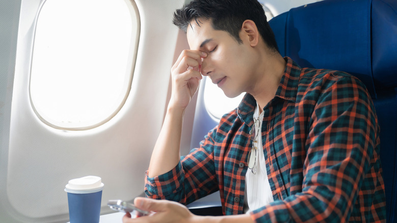 Man on plane who is feeling unwell