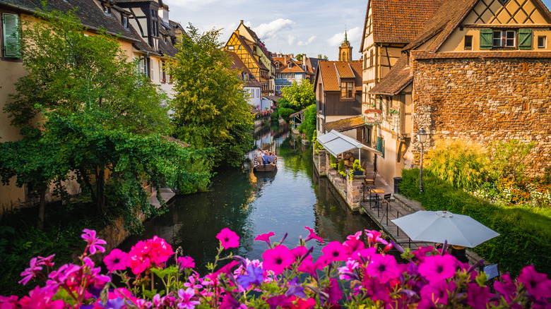 Flowers and small boat on canal in medieval French town of Colmar