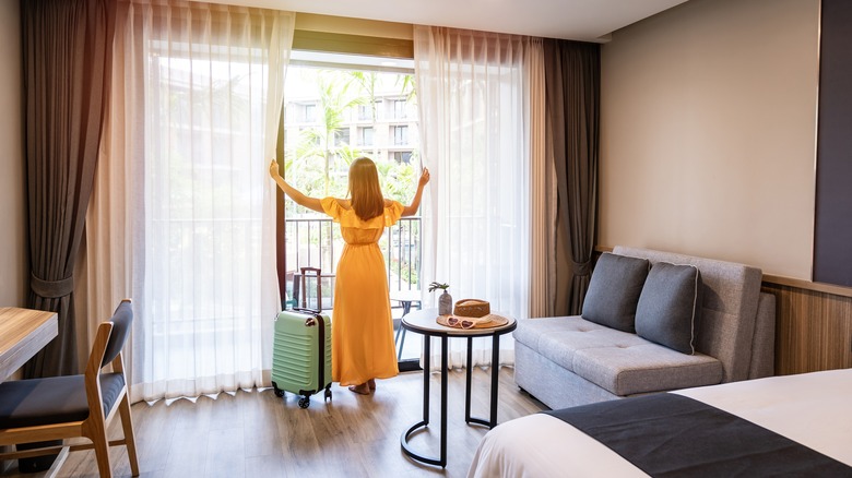 Woman looking out hotel window