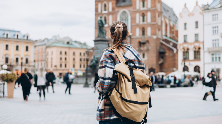 woman with backpack in city square