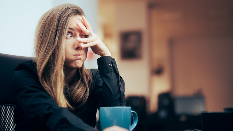 A woman in a cafe expresses embarrassment