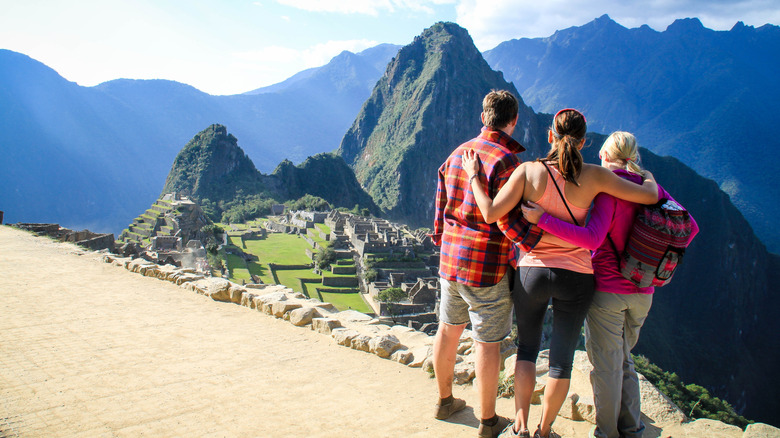 Three people overlooking Machu Picchu