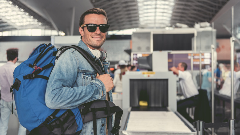 Traveler wearing headphones before security