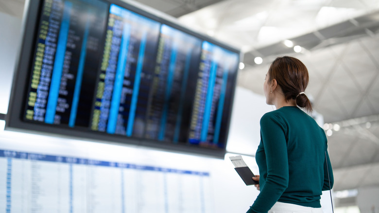 person reading departure board at airoort