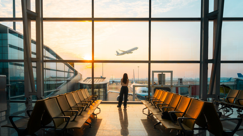 person watching an airplane take off from an airport