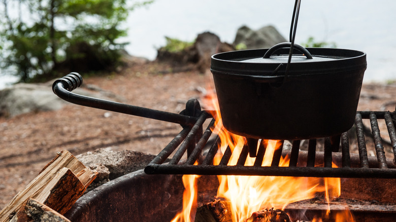 A dutch oven cooking over a fire