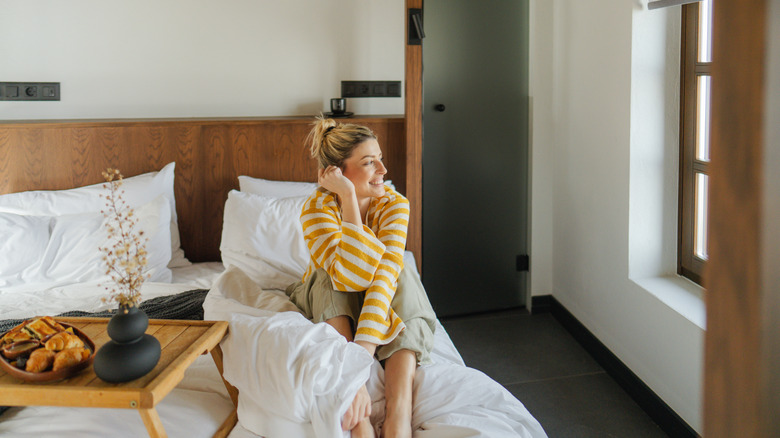 Hotel guest relaxing in bed