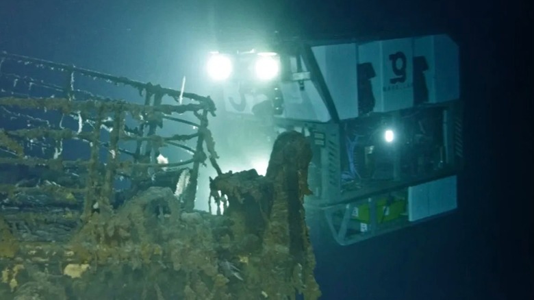 camera light on rusty Titanic bow, dark sea