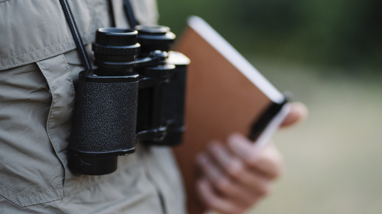 Park ranger with binoculars and journal