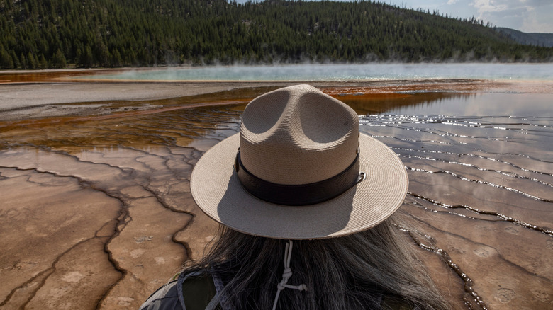woman with hat looking at thermal pool
