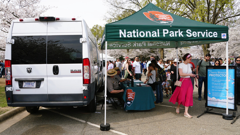 van with information tent, people