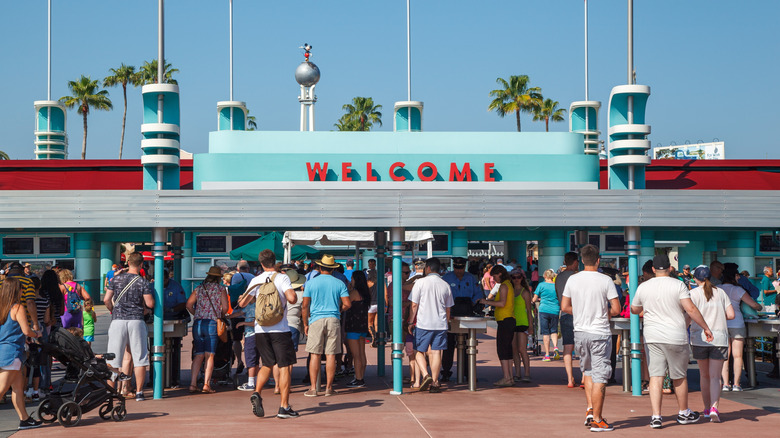 People entering under Disney's Hollywood Studios welcome sign