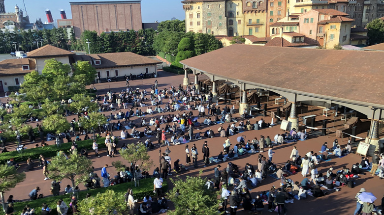 Long lines of people sitting outside DisneySea