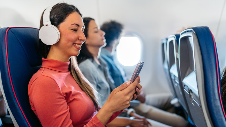 woman using phone on plane