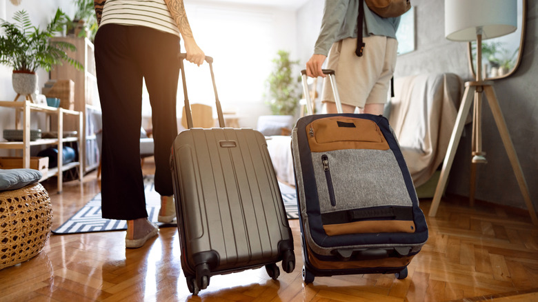 People rolling suitcases behind into a vacation home rental