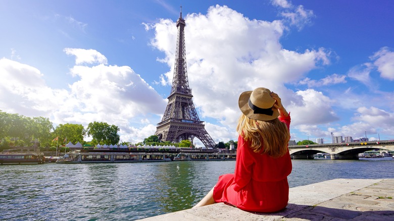 woman sitting across from eiffel tower