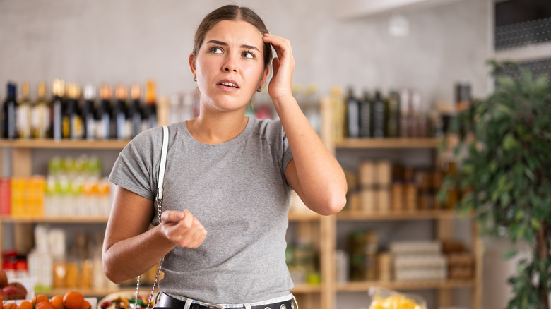 A woman looking confused at the supermarket