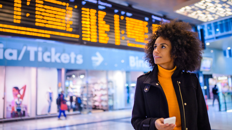 traveler in an airport with phone in hand