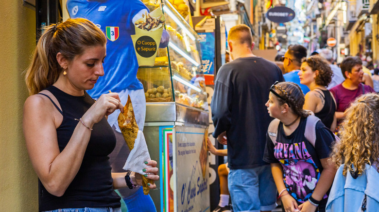 Woman enjoying street food in the historic center of Naples